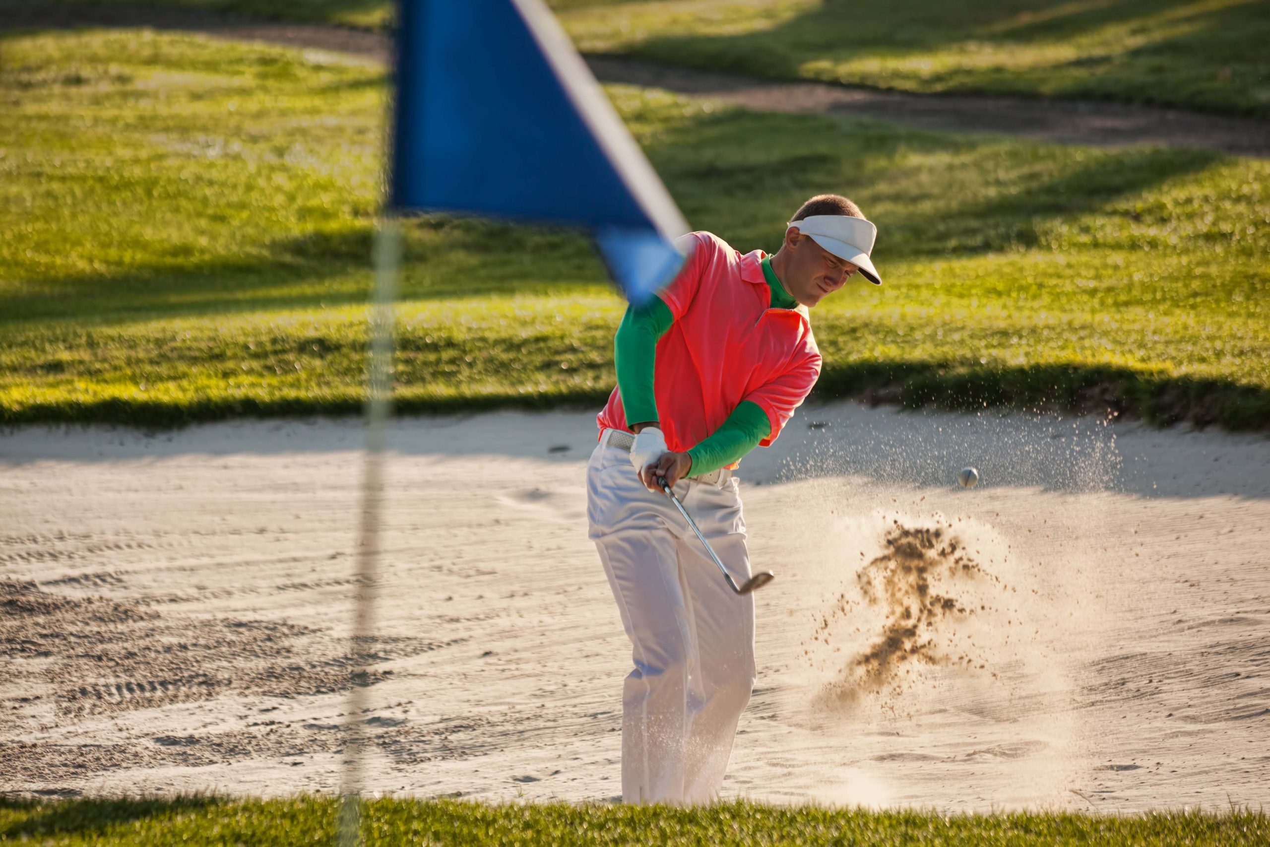 Man playing golf from the bunker